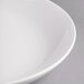 A close-up of a white Reserve by Libbey Silk porcelain serving bowl with a rim.