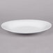 A white narrow rim oval porcelain platter on a white background.