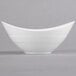 A close-up of a white Reserve by Libbey Silk oval bowl with a curved edge.