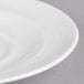 A close up of a white porcelain saucer with a curved line.