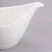 A close-up of a white Reserve by Libbey Royal Rideau porcelain sauce boat.