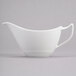 A white porcelain sauce boat with a handle.