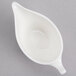A white porcelain sauce boat with a handle.
