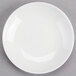 A white porcelain round dipping dish with a white rim.