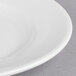 A close-up of a Libbey Royal Rideau white porcelain plate with a wide rim.