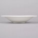 A white Reserve by Libbey Silk porcelain coupe bowl on a gray surface.