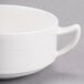 A white porcelain soup cup with two handles.