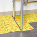 A Spilfyter high visibility absorbent pad with yellow caution signs on the floor.