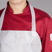 A person wearing a red and white Chicopee Chix disposable food service apron over a white chef's uniform.