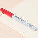 A red Universal permanent marker on a piece of paper.