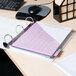 A white Avery heavy-duty view binder on a desk with pink and purple paper.