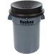 A gray round Husky trash can with a black funnel top lid.