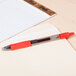 A Pilot red G2 pen on a notepad.