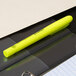 A Universal fluorescent yellow chisel tip highlighter pen with a pocket clip on a black binder.