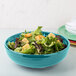 A Fiesta turquoise china bistro bowl filled with salad and croutons.