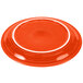 A red Fiesta Healthcare China plate with a white rim.