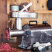 A Weston Pro Series electric meat grinder on a table with meat being poured into it.