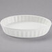 A white oval fluted Tuxton China dish with a white rim.