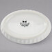 A white Tuxton china oval fluted dish with black text.