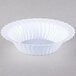 A close up of a white Fineline plastic bowl with wavy edges.