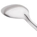 A close-up of an American Metalcraft stainless steel solid spoon with a silver handle.
