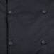 A close up of a black Mercer Culinary long sleeve chef jacket with buttons.