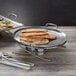 An American Metalcraft stainless steel griddle with flat bread on a table.