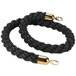A black braided rope with gold ends.