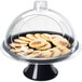 A Cal-Mil glass dome covering a plate of cookies on a display table.