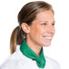 A woman wearing a white chef's coat and a green Intedge chef neckerchief.