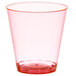 A red plastic shot cup with a white background.