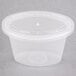 A Newspring clear plastic oval souffle container with a lid.
