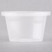 A clear Newspring oval plastic souffle container with a lid.