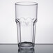 A close-up of a clear Carlisle plastic tumbler with a small rim.