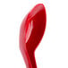 A close-up of a red GET Red Sensation melamine soup spoon with a hole in the middle.