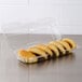 A Dart clear hinged plastic container holding six pastries.
