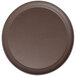 A brown round non-skid serving tray on a table.