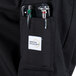 A black Mercer Culinary Genesis chef jacket with a pocket for tools and a phone.