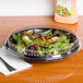 A salad in a Genpak clear plastic container with a clear dome lid.