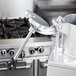 A Robot Coupe food processor pusher with a metal rod and black handle.