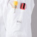 A white Mercer Culinary chef jacket with a pocket and a pen.
