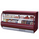 A Turbo Air red refrigerated deli case with food items on it.