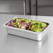 A Choice stainless steel 1/4 size steam table pan filled with salad on a counter.