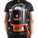 A man wearing a black shirt and a Hoover backpack vacuum cleaner.