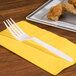 A Visions white heavy weight plastic fork on a yellow napkin.