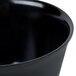 A close up of a black Carlisle Dallas Ware bouillon cup with a handle.