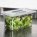 A Carlisle clear plastic lid on a container of lettuce.