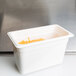 A white Cambro 1/3 size plastic food pan with cheese inside.