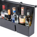 A black metal wall mounted Cambro 7-bottle speed rail holding clear and blue labeled bottles of alcohol.