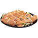 A plate of sandwiches on a black WNA Comet round catering tray.